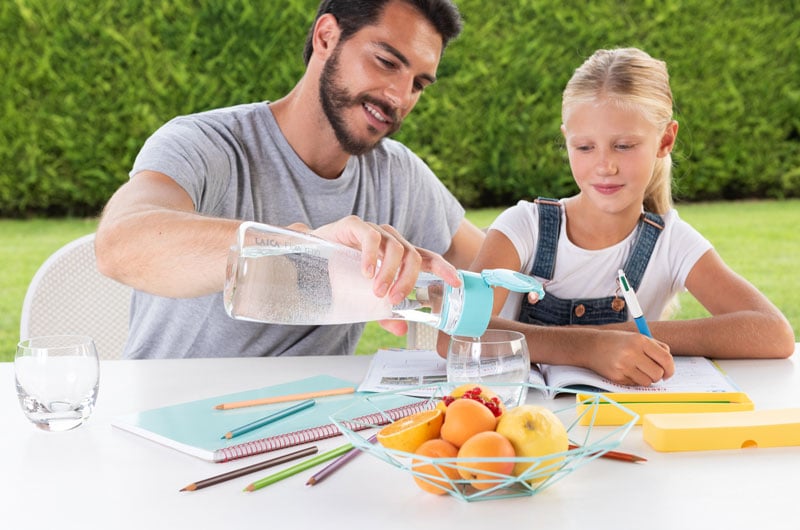 Papà-versa-alla-figlia-un-bicchiere-di-acqua-con-la-bottiglia-filtrante-Flow-n-go-di-Laica